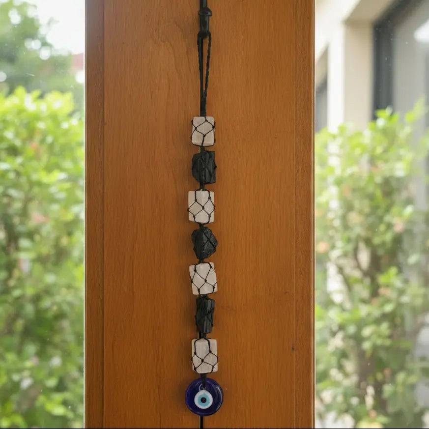 Black Tourmaline, Selenite & Evil Eye Hanger Invite protection, balance, and positive energy into your surroundings with the Black Tourmaline, Selenite & Evil Eye Hanger. Handcrafted using natural Black Tourmaline and Selenite, this elegant hang